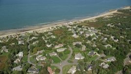 5.5K aerial stock footage flying over small coastal town, pan left to beach, Cape Cod, Dennis, Massachusetts Aerial Stock Footage | AX143_154E