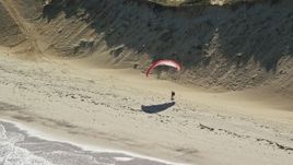 5.5K aerial stock footage flying by parachuter on the beach, Cape Cod, Wellfleet, Massachusetts Aerial Stock Footage | AX144_026