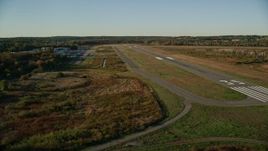 6k aerial stock footage flying by trees, autumn, approach the Norwood Memorial Airport, Massachusetts Aerial Stock Footage | AX145_131E