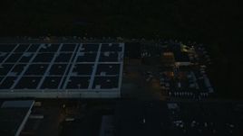 6k aerial stock footage flying by a large warehouse, Hyde Park, Massachusetts, night Aerial Stock Footage | AX146_160E