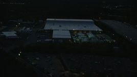 6k aerial stock footage flying by a warehouse, Westwood, Massachusetts, night Aerial Stock Footage | AX146_166