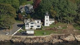 6K aerial stock footage of a lighthouse nestled among trees along cove, autumn, Beverly, Massachusetts Aerial Stock Footage | AX147_053