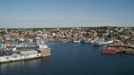 6K aerial stock footage flying by coastal town, small warehouse buildings, Gloucester, Massachusetts Aerial Stock Footage | AX147_087