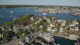 6K aerial stock footage flying by coastal town, revealing a small factory, boats, Gloucester, Massachusetts Aerial Stock Footage | AX147_096E