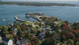 6K aerial stock footage flying over coastal community in autumn toward a lighthouse, New Castle, New Hampshire Aerial Stock Footage | AX147_191E