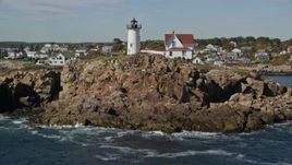 6K aerial stock footage flying low over water, tilt up to reveal Cape Neddick Light, York, Maine Aerial Stock Footage | AX147_241E
