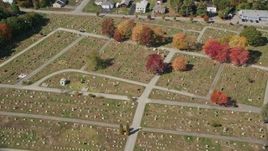 6K aerial stock footage flying over dense, colorful forest, rural homes, approach cemetery, Biddeford, Maine Aerial Stock Footage | AX147_279