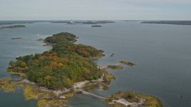 6K aerial stock footage flying by Clapboard Island with colorful autumn trees, Falmouth, Maine Aerial Stock Footage | AX147_367