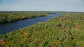6k aerial stock footage flying by a colorful forest, Biscay Pond, autumn, Damariscotta, Maine Aerial Stock Footage | AX148_023