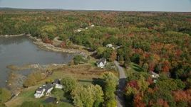 6K aerial stock footage flying over forest and rural homes, revealing a pond, autumn, Waldoboro, Maine Aerial Stock Footage | AX148_032E