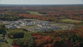 6K aerial stock footage orbiting Maine State Prison, colorful forest, autumn, Warren, Maine Aerial Stock Footage | AX148_062E