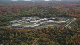 6K aerial stock footage orbiting Maine State Prison, colorful forest, autumn, Warren, Maine Aerial Stock Footage | AX148_065E