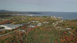 6K aerial stock footage flying by forest, warehouse buildings, small coastal town, autumn, Rockland, Maine Aerial Stock Footage | AX148_075E