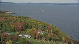 6K aerial stock footage flying by foliage, a sailboat, West Penobscot Bay, autumn, Rockport, Maine Aerial Stock Footage | AX148_103