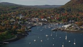 6K aerial stock footage flying by small coastal town and Camden Harbor, autumn, Camden, Maine Aerial Stock Footage | AX148_120E