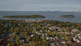 5.5K aerial stock footage flying away from harbor and over coastal town with fall foliage, Bar Harbor, Maine Aerial Stock Footage | AX148_204E