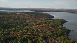 5.5K aerial stock footage flying over road winding through forest filled with fall foliage, Bar Harbor, Maine Aerial Stock Footage | AX148_231