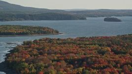 5.5K aerial stock footage flying away from the bay and over forest with fall foliage, Trenton, Maine Aerial Stock Footage | AX149_002