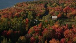 5.5K aerial stock footage flying by rural home and road among forest with fall foliage, Trenton, Maine Aerial Stock Footage | AX149_005