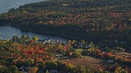 5.5K aerial stock footage flying by a coastal town toward the water surrounded by autumn trees, Blue Hill, Maine Aerial Stock Footage | AX149_012