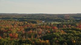 5.5K aerial stock footage flying by a colorful forest, isolated home, autumn, Penobscot, Maine Aerial Stock Footage | AX149_062