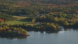 5.5K aerial stock footage flying by rural waterfront homes, colorful forest, autumn, Penobscot, Maine Aerial Stock Footage | AX149_066