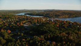 5.5K aerial stock footage flying over trees by a small town on Penobscot River, autumn, Bucksport, Maine Aerial Stock Footage | AX149_108