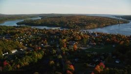 5.5K aerial stock footage flying by a small town on the Penobscot River in autumn, Bucksport, Maine Aerial Stock Footage | AX149_109