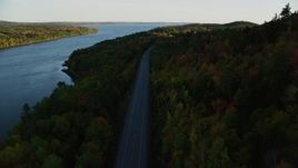 5.5K aerial stock footage flying over Route 3, colorful forest in autumn, Stockton Springs, Maine, sunset Aerial Stock Footage | AX149_117