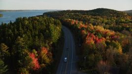 5.5K aerial stock footage flying over road among forest of fall foliage, autumn, Stockton Springs, Maine, sunset Aerial Stock Footage | AX149_119