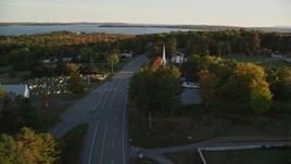 5.5K aerial stock footage following road past church and cemetery, autumn, Stockton Springs, Maine, sunset Aerial Stock Footage | AX149_127E