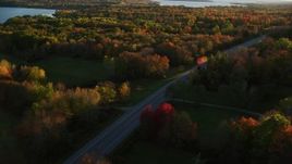 5.5K aerial stock footage tracking car on road through forest, autumn, Stockton Springs, Maine, sunset Aerial Stock Footage | AX149_132