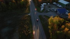 5.5K aerial stock footage tracking car on road through forest in autumn, Stockton Springs, Maine, sunset Aerial Stock Footage | AX149_134