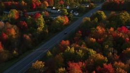 5.5K aerial stock footage tracking car on road through small town nestled among trees, autumn, Stockton Springs, Maine, sunset Aerial Stock Footage | AX149_139