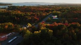 5.5K aerial stock footage tracking a car on road passing by small town, autumn, Stockton Springs, Maine, sunset Aerial Stock Footage | AX149_144
