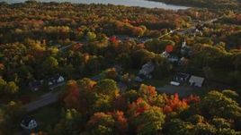 5.5K aerial stock footage flying away from small town and trees, autumn, Stockton Springs, Maine, sunset Aerial Stock Footage | AX149_146