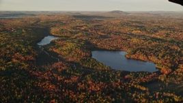 5.5K aerial stock footage flying by ponds surrounded by forest in autumn, Searsport, Maine, sunset Aerial Stock Footage | AX149_154