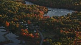 5.5K aerial stock footage flying by ponds surrounded by forest in autumn, Belfast, Maine, sunset Aerial Stock Footage | AX149_157E