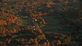 5.5K aerial stock footage flying by a forest and rural homes, Poors Mill Road, autumn, Belfast, Maine, sunset Aerial Stock Footage | AX149_166