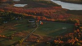 5.5K aerial stock footage approaching a rural home near Route 3, forest in autumn, Belmont, Maine, sunset Aerial Stock Footage | AX149_169E