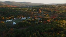 5.5K aerial stock footage approaching small rural town, colorful forest in autumn, Searsmont, Maine, sunset Aerial Stock Footage | AX149_175