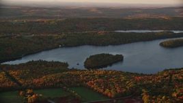 5.5K aerial stock footage flying by small forested islands, Saint George Lake, autumn, Liberty, Maine, sunset Aerial Stock Footage | AX149_193