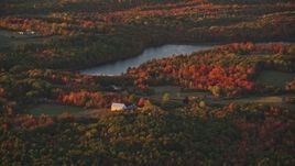 5.5K aerial stock footage flying by rural homes, forest and Beech Pond, autumn, Palermo, Maine, sunset Aerial Stock Footage | AX149_199