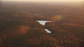 5.5K aerial stock footage flying by colorful forest, Savade Pond, Fox Pond, autumn, Windsor, Maine, sunset Aerial Stock Footage | AX149_202E