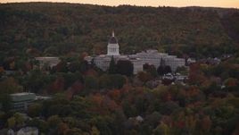 5.5K aerial stock footage flying by the Maine State House, dense trees, autumn, Augusta, Maine, twilight Aerial Stock Footage | AX149_249E