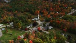 5.5K aerial stock footage flying by East Winthrop Baptist Church, colorful foliage, autumn, Winthrop, Maine Aerial Stock Footage | AX150_009