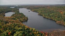 5.5K aerial stock footage flying over colorful forest, approach Upper Narrows Pond, autumn, Winthrop, Maine Aerial Stock Footage | AX150_010E