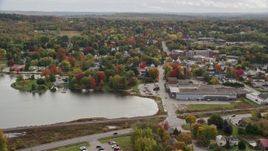 5.5K aerial stock footage flying by warehouse and homes, small town, autumn, Winthrop, Maine Aerial Stock Footage | AX150_017E