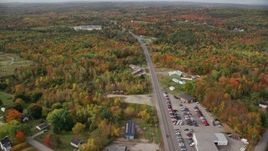5.5K aerial stock footage flying over car dealership, Route 11, colorful foliage in autumn, Winthrop, Maine Aerial Stock Footage | AX150_024