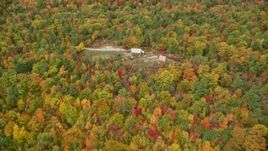 5.5K aerial stock footage flying over colorful forest, approach an isolated home, autumn, Leeds, Maine Aerial Stock Footage | AX150_032E